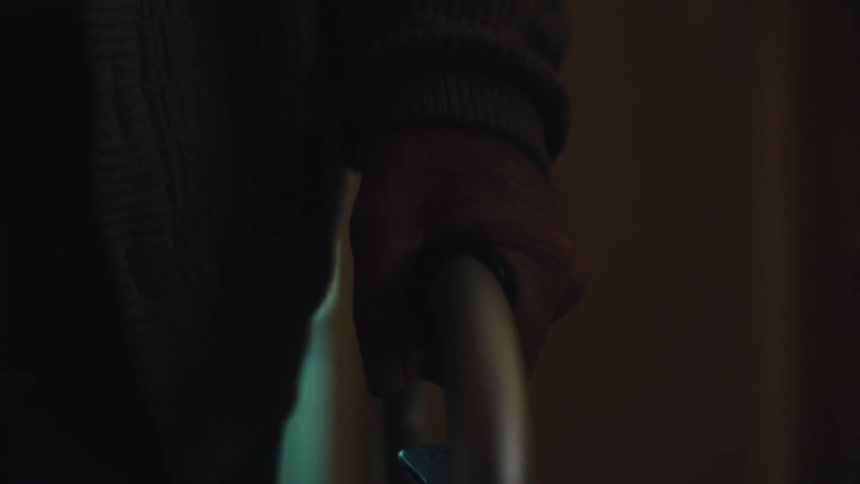 The hand of an elderly person using a metal walker to walk