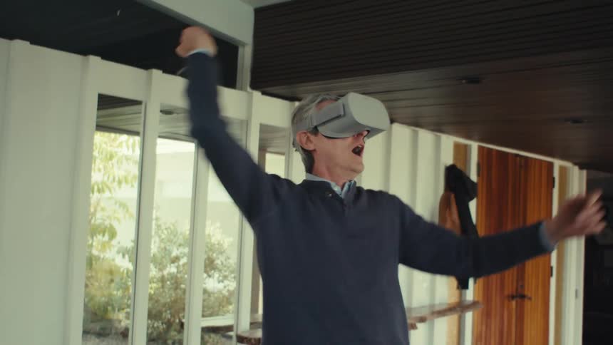 A man wearing a virtual reality headset playing a game indoors