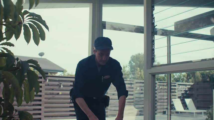 Electrician with a ladder and a tape measure measuring the distance from the ceiling to the light bulb