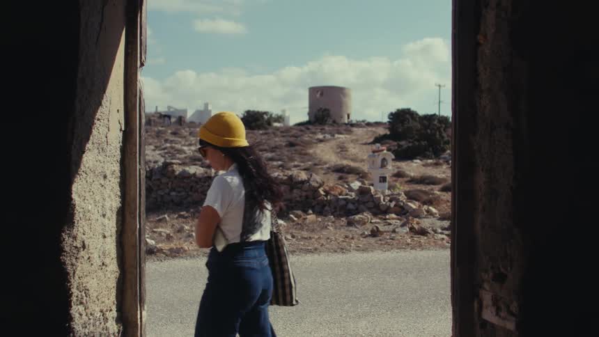 A back view clip of a lady putting on a yellow head warmer
