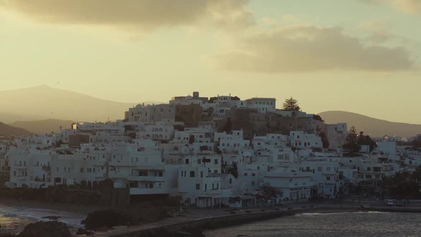 A picturesque greek hillside town bathed in the golden hues of sunset
