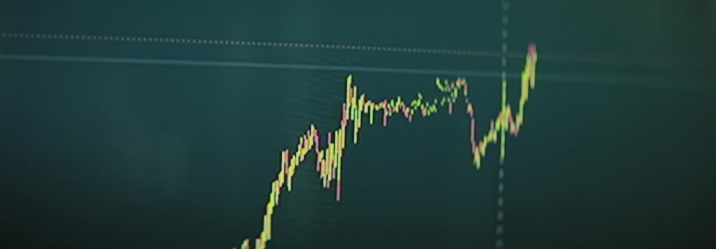 A graph rises on the screen