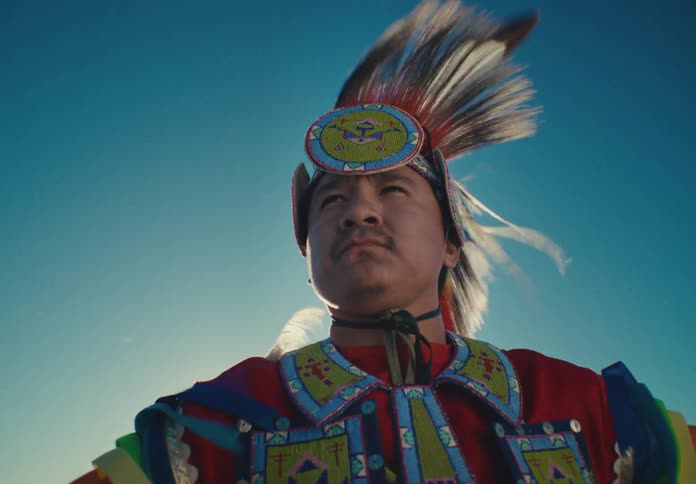 Portrait of a man wearing colorful clothing and with feathers on his head