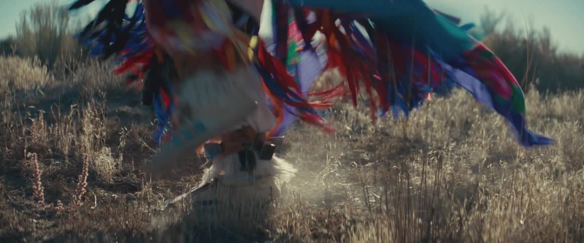 Legs of a person dancing while wearing native american attire
