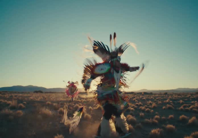 Group of people in a field dancing in traditional clothes