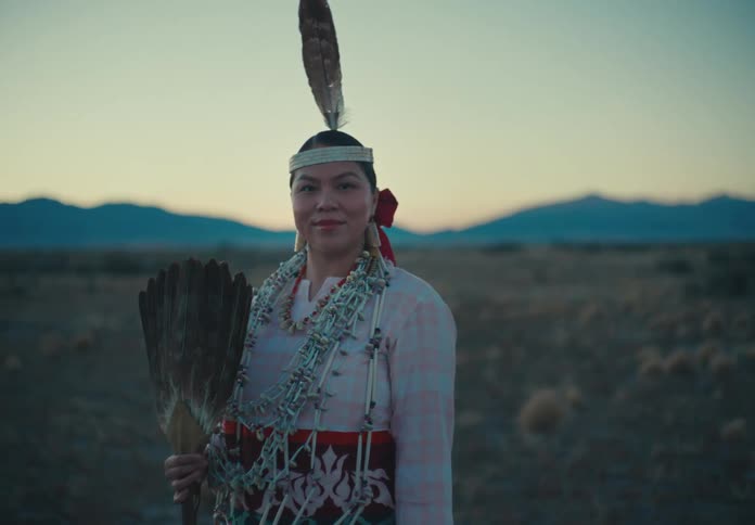 Native american woman in traditional dress holding a feather fan