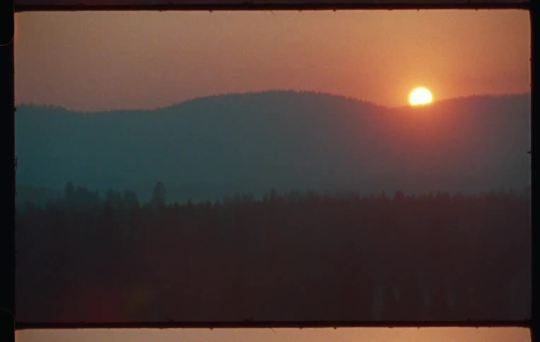 The sun sets behind a mountain