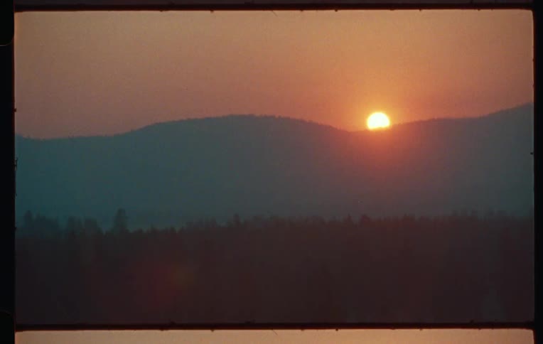 The sun sets over a mountain
