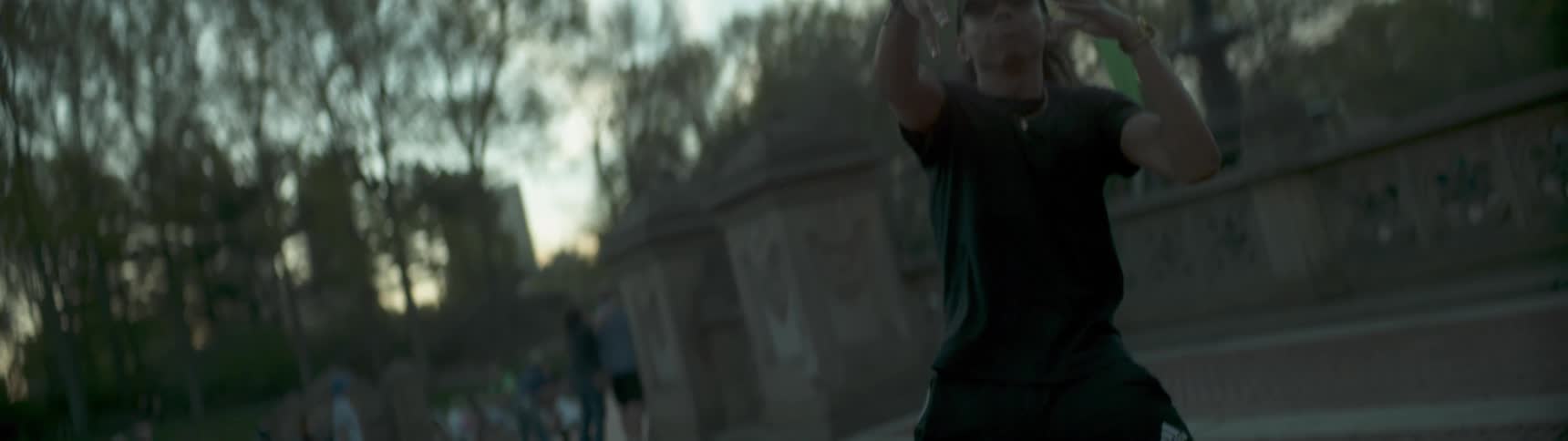 A man is performing a dance in a park