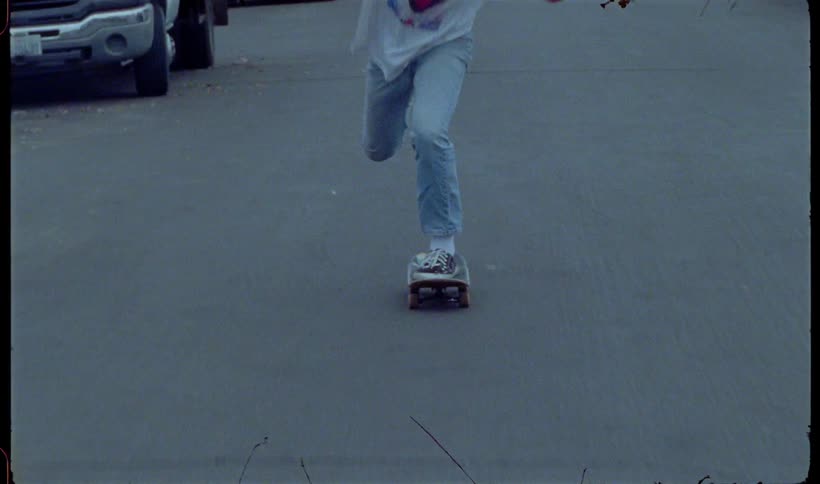 A teenager is skateboarding down the road