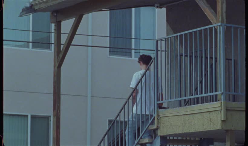A teenager leaves his apartment with a skateboard