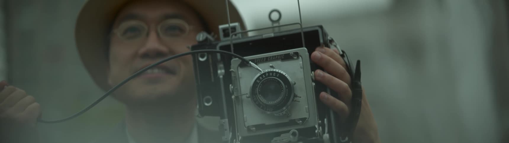 A man points his camera smiling