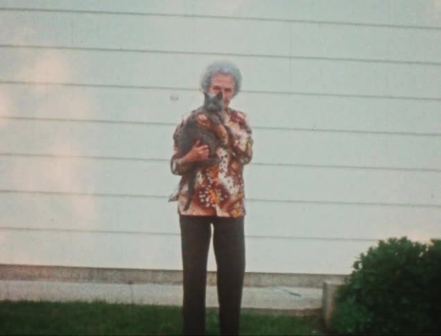 Elderly woman holding a gray fur cat