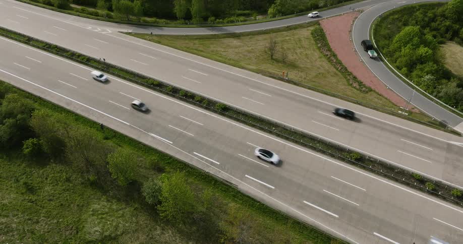An aerial view of a multilane highway with several cars traveling in both directions