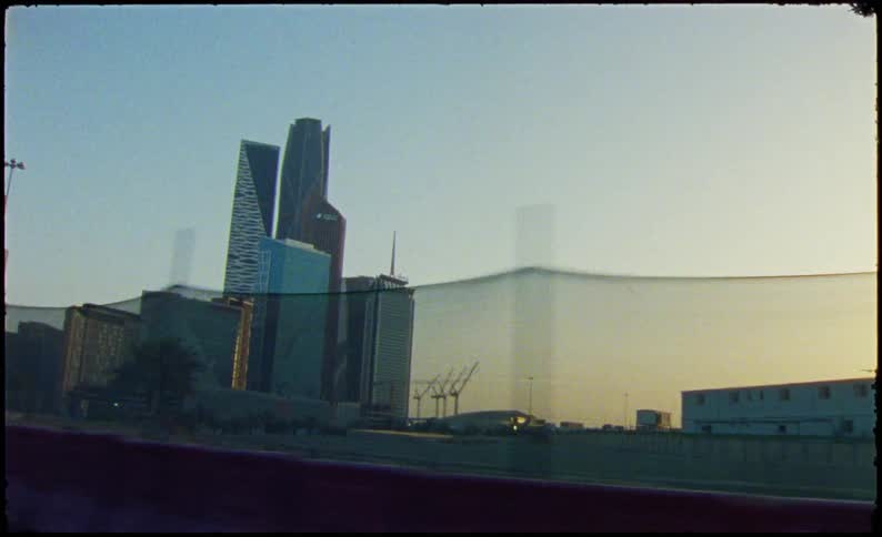 A cityscape with a large construction site in the foreground and towering skyscrapers in the background