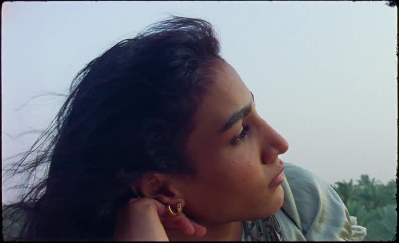A woman is laying on a rock by the forest