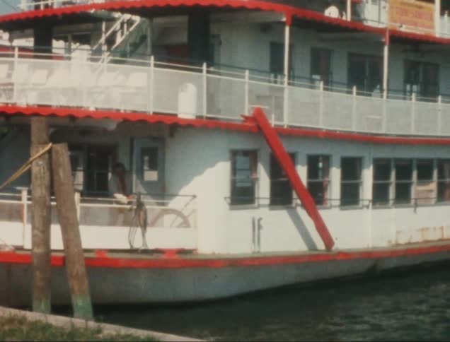 Man exiting the interior of a large boat before walking toward the pier