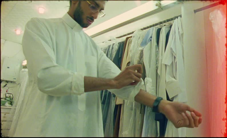 A man is trying on clothes in a retail store by himself