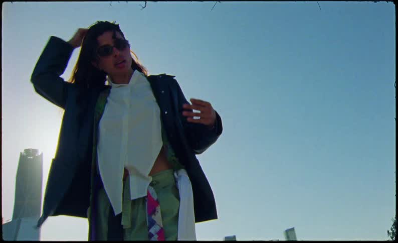 A woman stands before the city