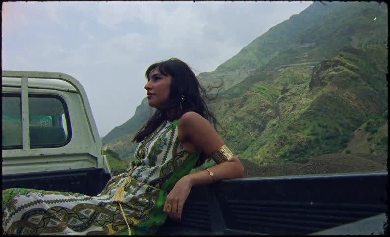 A clip of a female sitting at the back of a truck