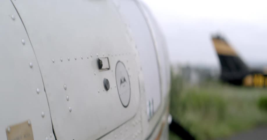 A pilot opens a compartment on a parked airplane