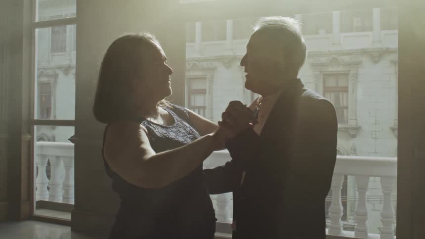Elderly couple dancing alone in a room together