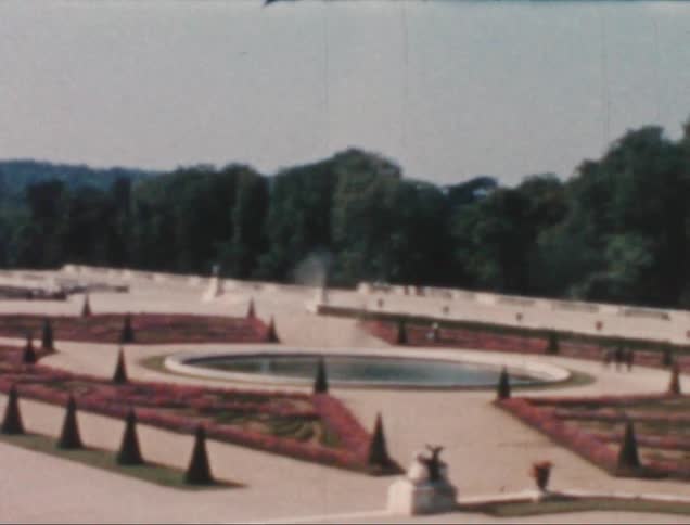 Park with flower fountain with people walking and trees in the background