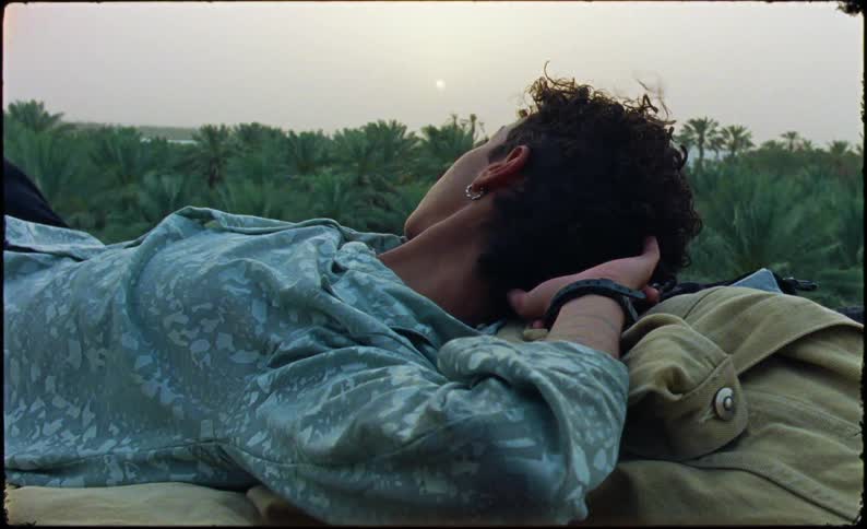 Woman lying in a jacket in a natural space with a tropical forest in the background