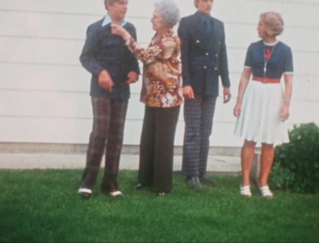 Vintage film of a family posing outside a house for a photo