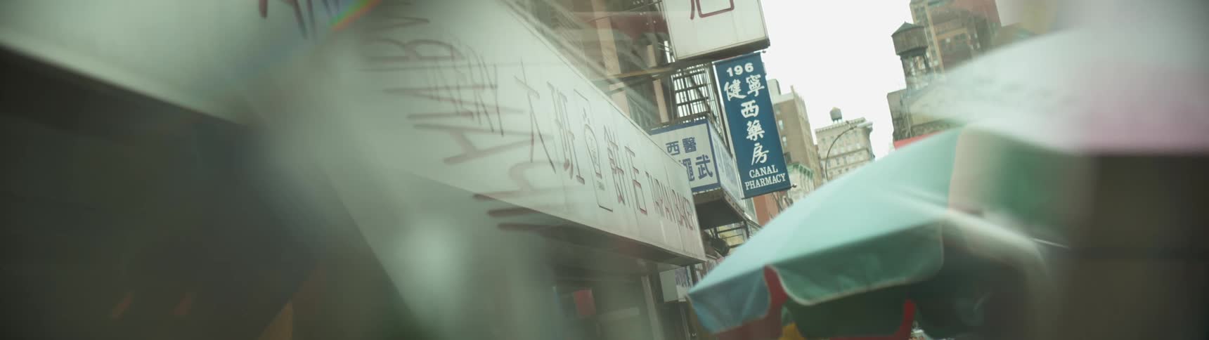 A close up of signs on buildings looking through a window