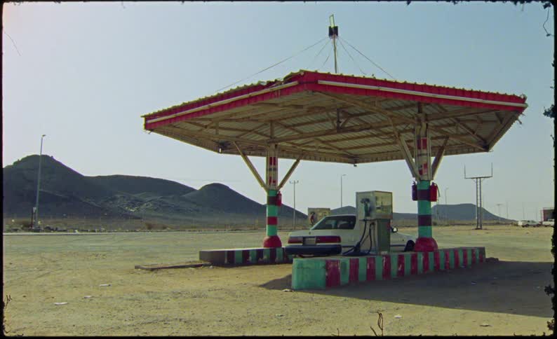 A car is parked at an old gas station