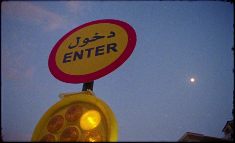 Upward view of a sign with a light in an outdoor area