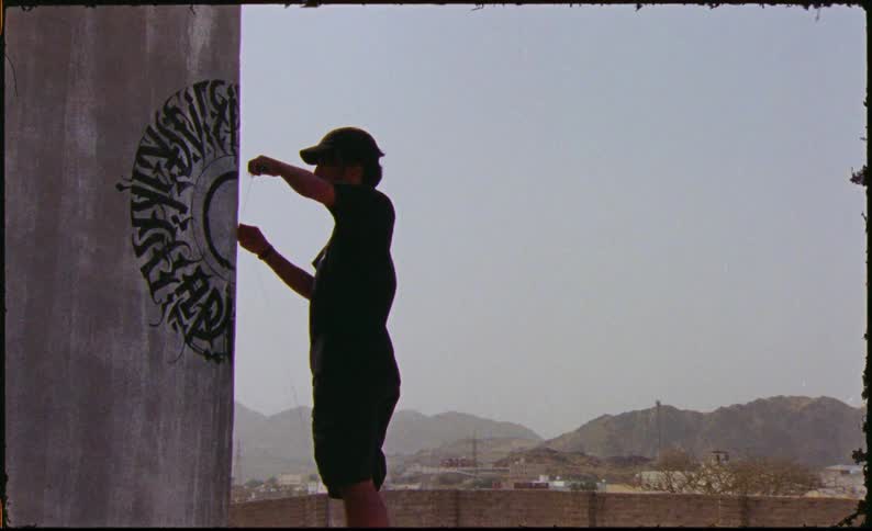 A man painting on a wall in the countryside