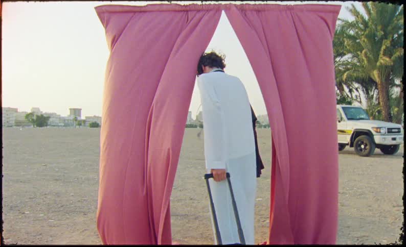 A clip of a male model holding some clothes