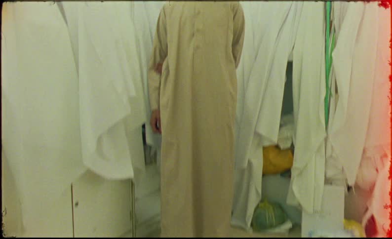 Arab man in long brown traditional clothing in an indoor space