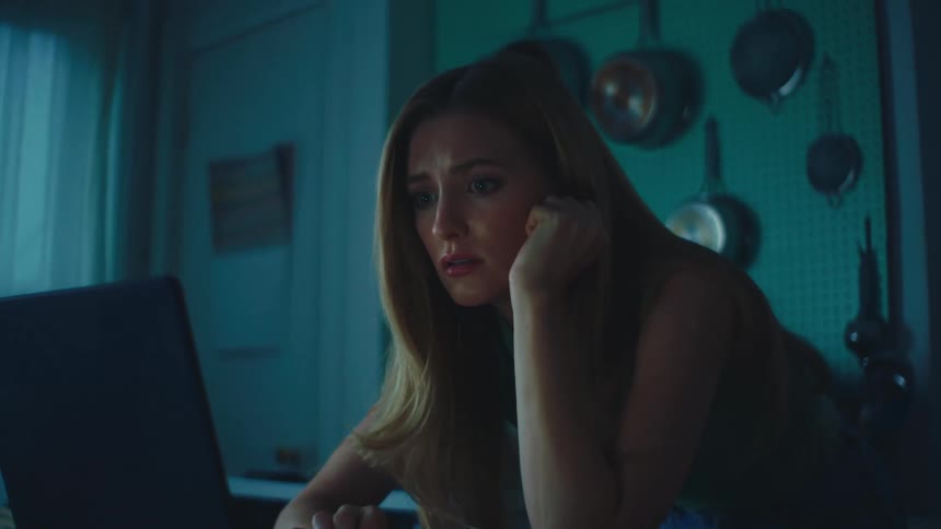 Blonde woman with sad expression and interacting with a laptop