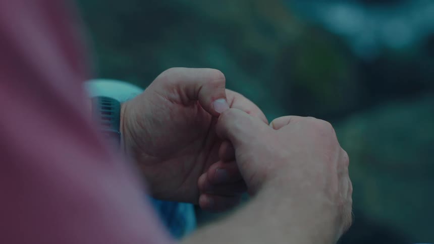 A person is picking at his nails outside