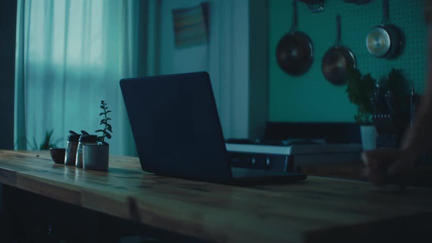 A woman walks past a laptop
