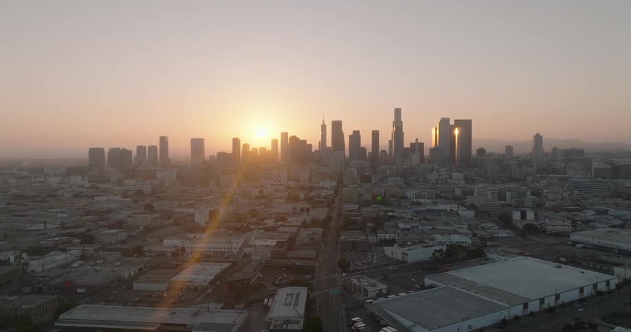 The sun is rising behind the buildings