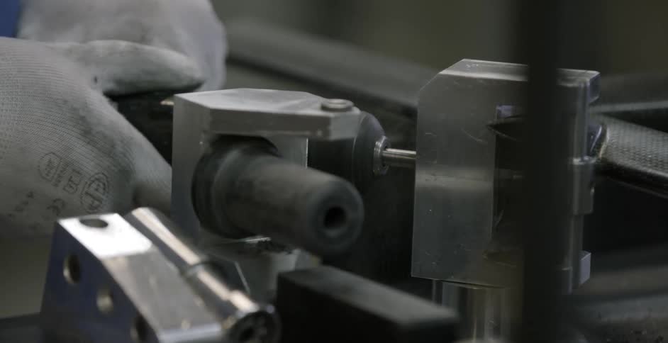 A worker uses a drill into steel