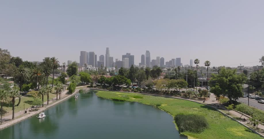 Aerial view of a park with a lake and boats and in the background skyscrapers of a metropolis