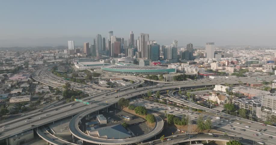 Aerial view of a highway with traffic and skyscrapers on the horizon