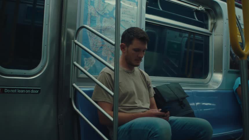 Man passenger in a metro texting on his cell phone