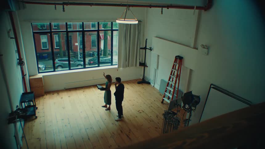 A real estate agent is showing off a loft to a client
