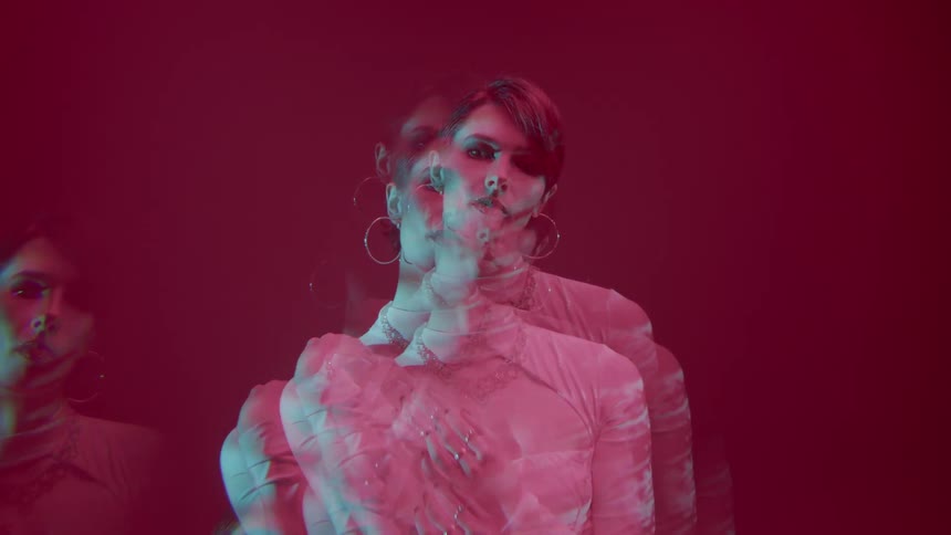 Multiple exposures of a woman in a white dress against a red background