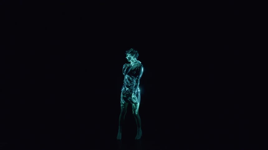 Woman in a dress performing in a dark room