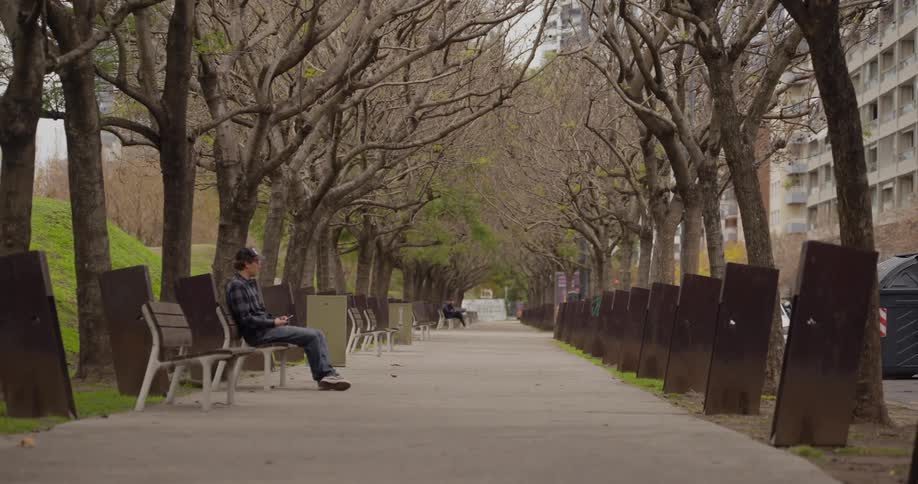 Man sitting on a bench in the corridor of a square