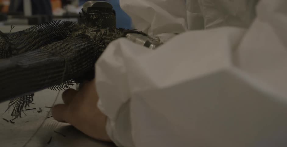 A person is wrapping thread around a machine