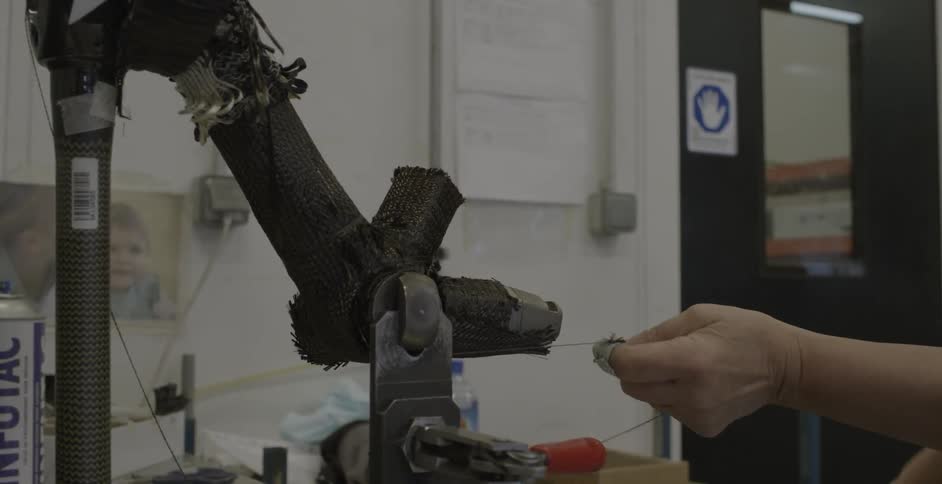Person threading a piece of machinery in a shop