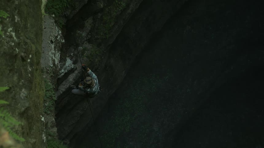 A man repels down a cliff